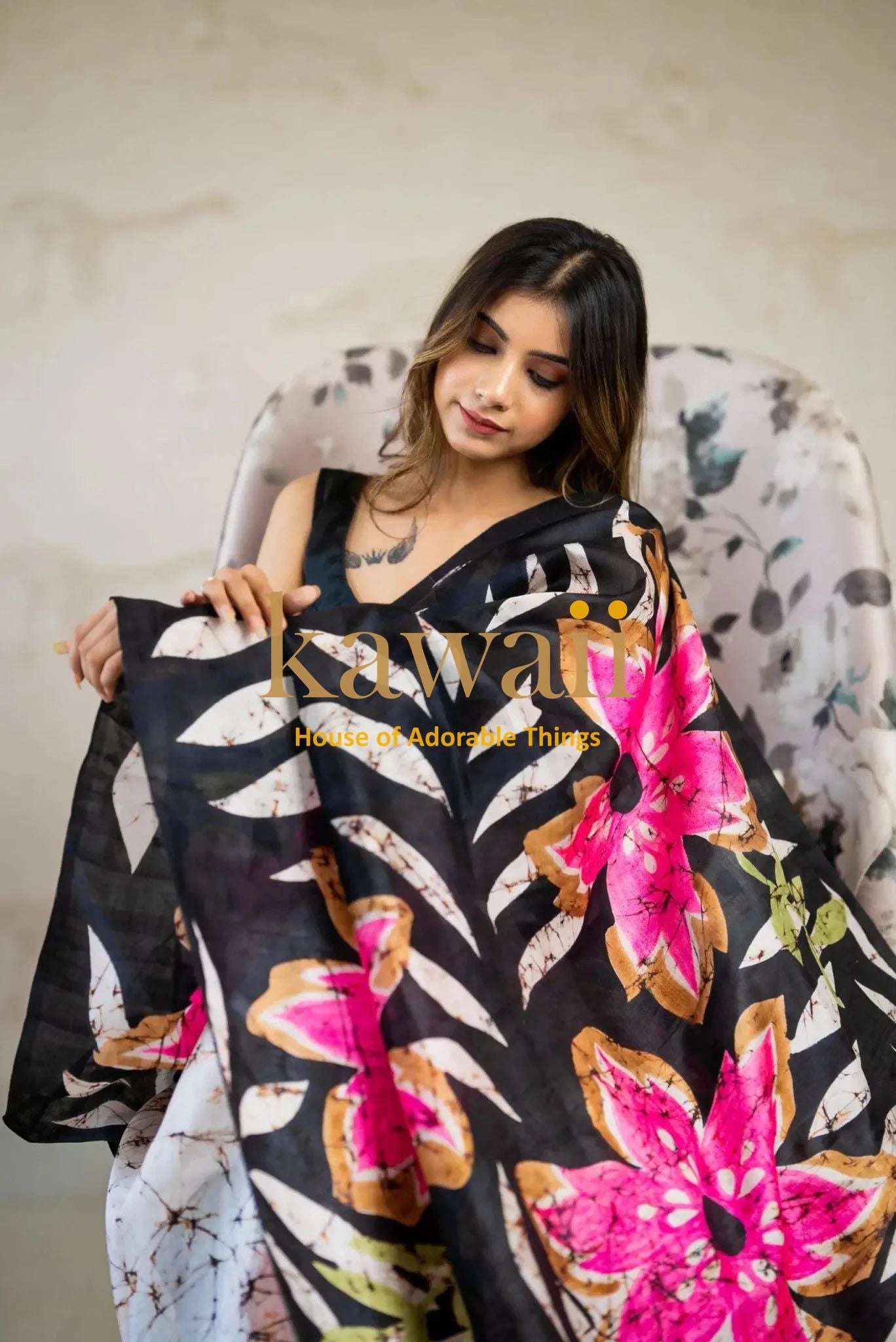 Woman draped in black batik saree with vibrant pink and green floral patterns by Kawaii